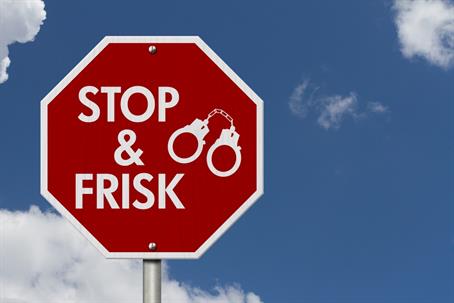 Stop and Frisk message with handcuffs on red street stop sign with sky 3D Illustration